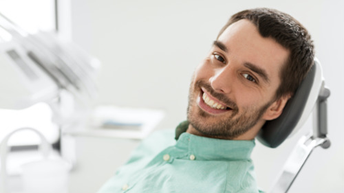 Smiling male patient in dental chair during Invisalign consultation in East Hills, NSW